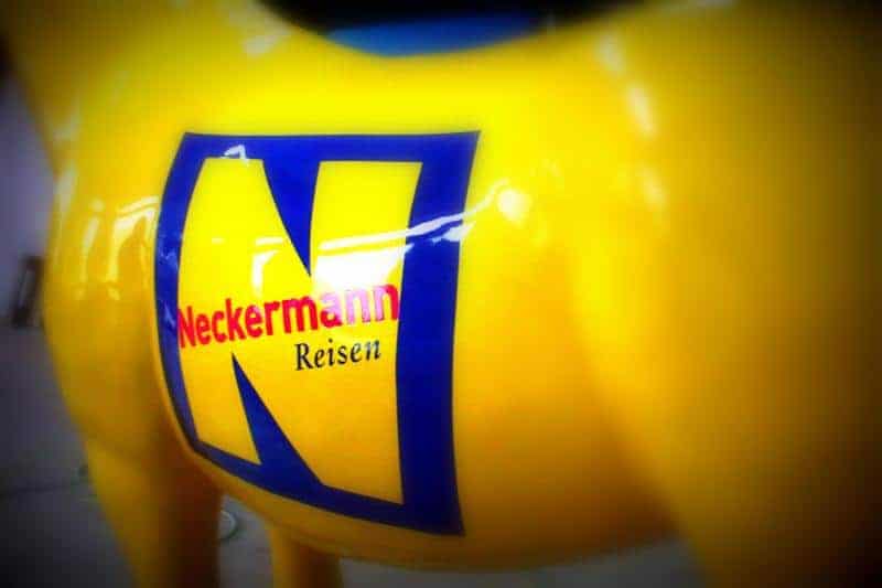 Figure publicitaire pour Neckermann. 2 Żółty obiekt z logo Neckermann Reisen.