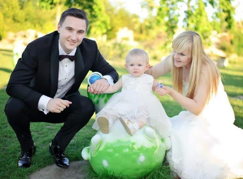 Figurines dans le parc d'attractions 2 Mężczyzna w garniturze i kobieta w sukni ślubnej z małym dzieckiem na świeżym powietrzu.