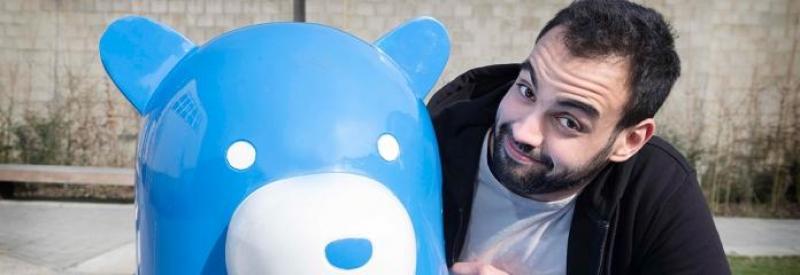 Ours sur un Banc 3 Mężczyzna obok niebieskiego posągu misia.