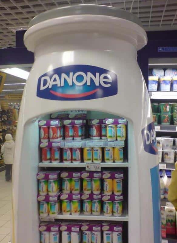 Dispositif de réfrigération publicitaire Actimel 1 Lodówka w kształcie butelki z logo Danone, wypełniona produktami jogurtowymi w sklepie.