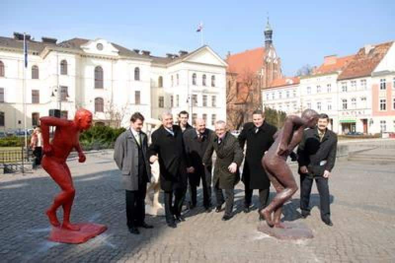 Promotion des Championnats du Monde IAAF 3 Grupa mężczyzn na placu z rzeźbami w mieście z budynkami w tle.