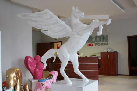 Logo en forme de Pégase 2 Biały posąg Pegaza w biurze z figurkami innych zwierząt.