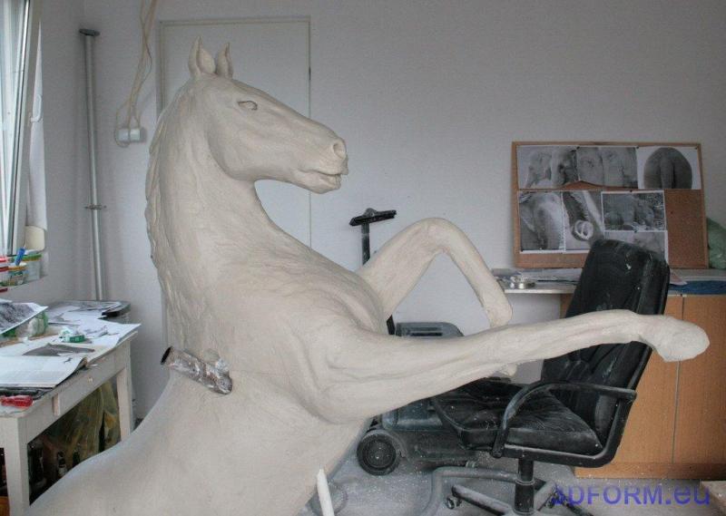 Logo en forme de Pégase 3 Rzeźba konia stojącego na tylnych nogach w warsztacie artysty.