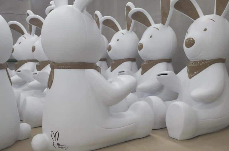 Tirelire Lapin 3 Białe figurki królików z brązowymi detalami siedzące w rzędach.