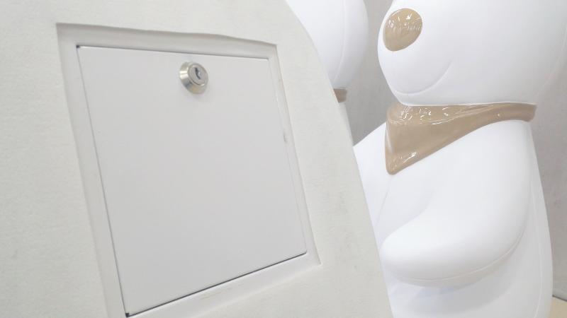 Tirelire Lapin 2 biała skrzynka zamykana na klucz na tle dużych, białych figur przypominających misie