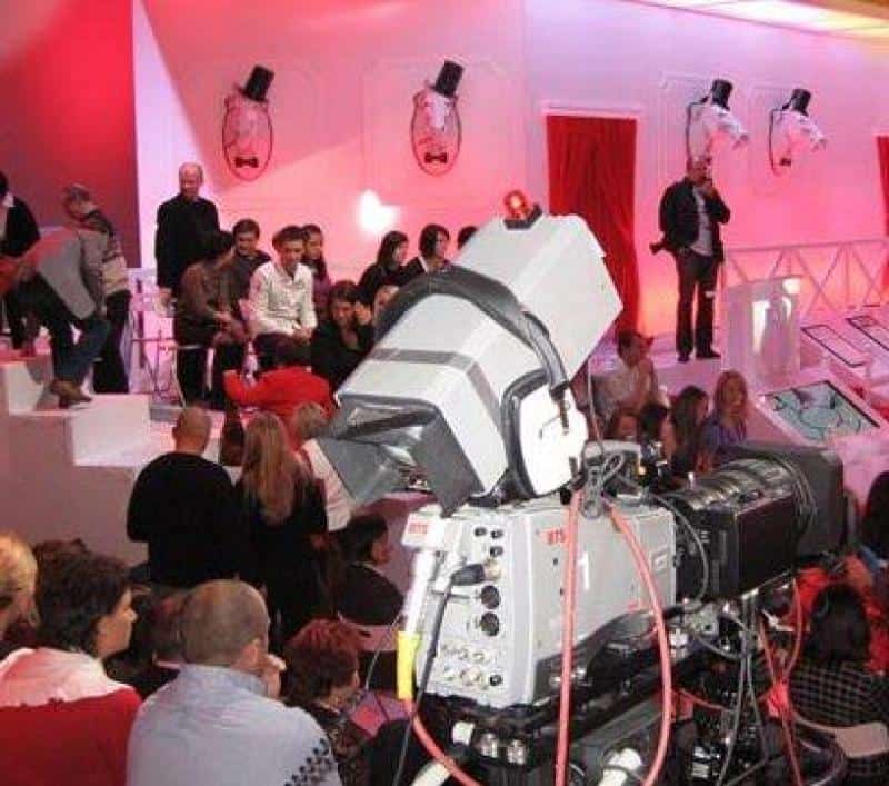 TVP2 - Éléments de Décor 3 Nagranie telewizyjne w studio z widownią i dużą kamerą na pierwszym planie. Dekoracje w czerwono-białej kolorystyce.