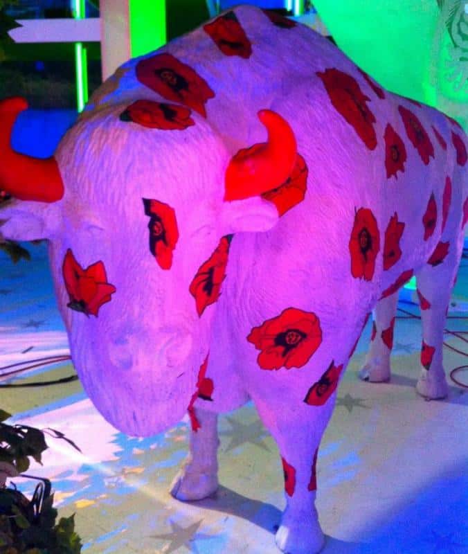 Bisons dans Rzeźba byka pomalowana na biało, z czerwonymi makami i czerwonymi rogami.