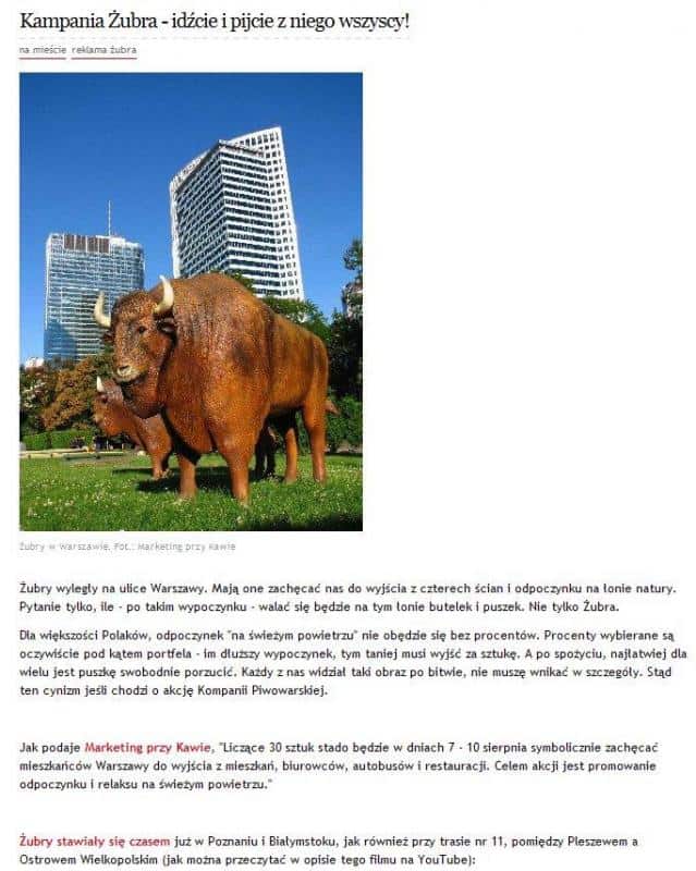 Figurines publicitaires de la bière Żubr 4 Żubr, figurka żubra na tle wieżowców w Warszawie.