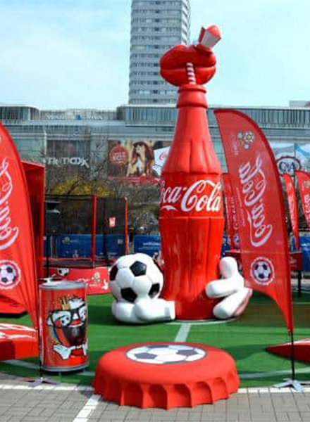Bouteille Coca-Cola pour l'Euro 2012 2 Dekoracja plenerowa z dużą butelką Coca-Coli, piłką nożną oraz czerwonymi flagami.