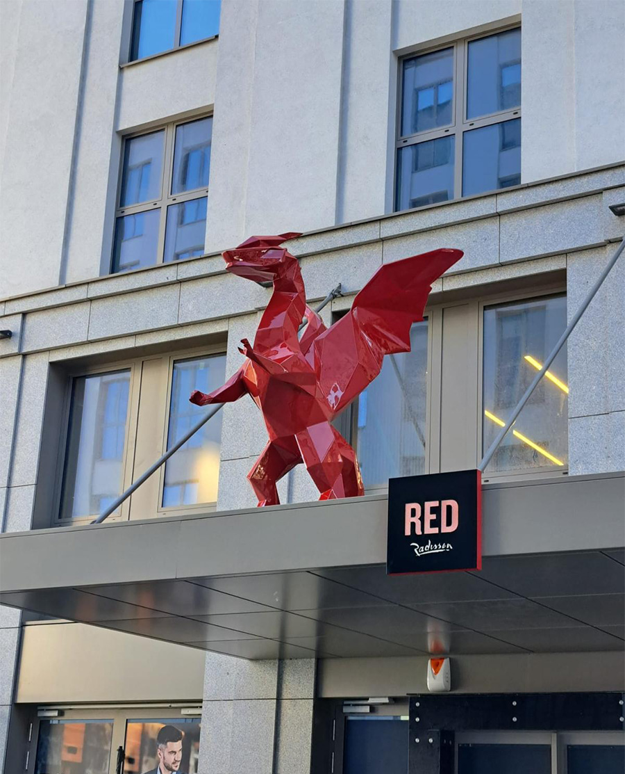 Czerwona rzeźba smoka przed budynkiem hotelu Radisson RED.
