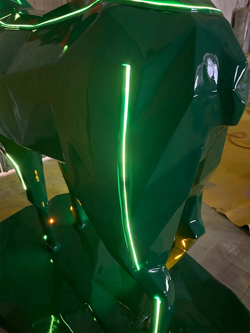 Zielona polerowana rzeźba z neonowymi zielonymi światłami.