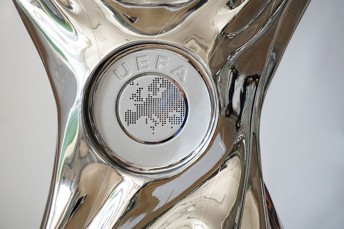 Srebrny puchar z centralnym medalionem zawierającym napis UEFA i wzór mapy Europy złożony z punktów.